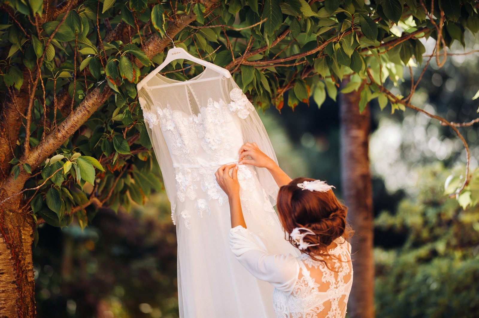 A bride standing next to a wedding dress at a villa in Italy