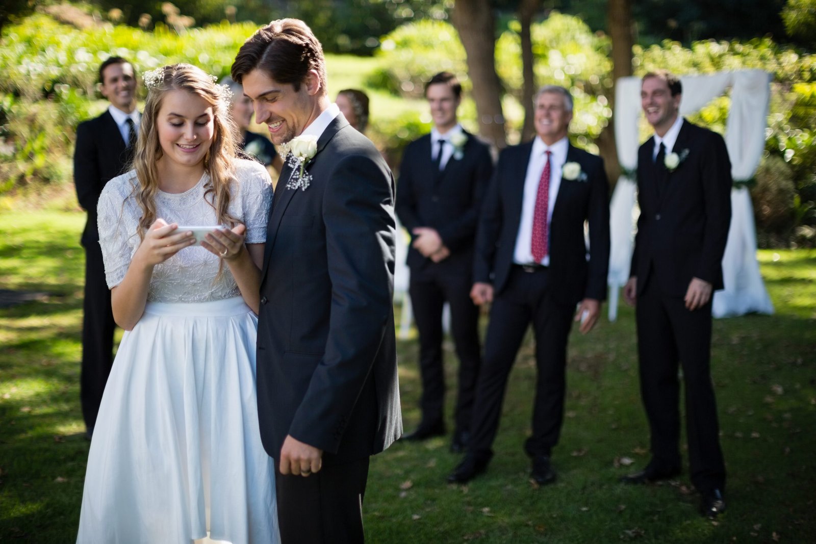 Bride and groom reviewing photographs on a mobile phone